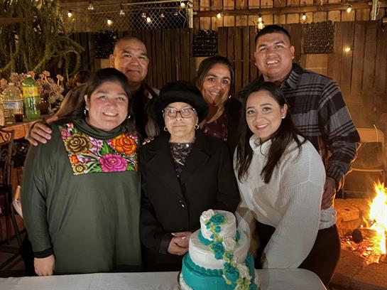 A joyful family gathers around a beautifully decorated birthday cake during a festive celebration.