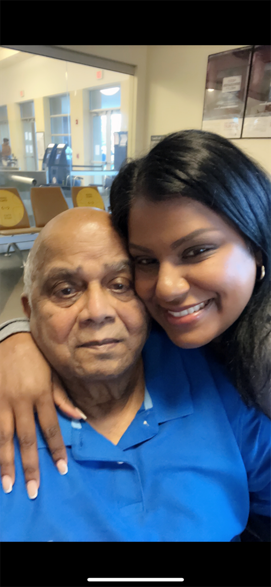 Granddaughter and grandfather share a joyful embrace while waiting at the airport.