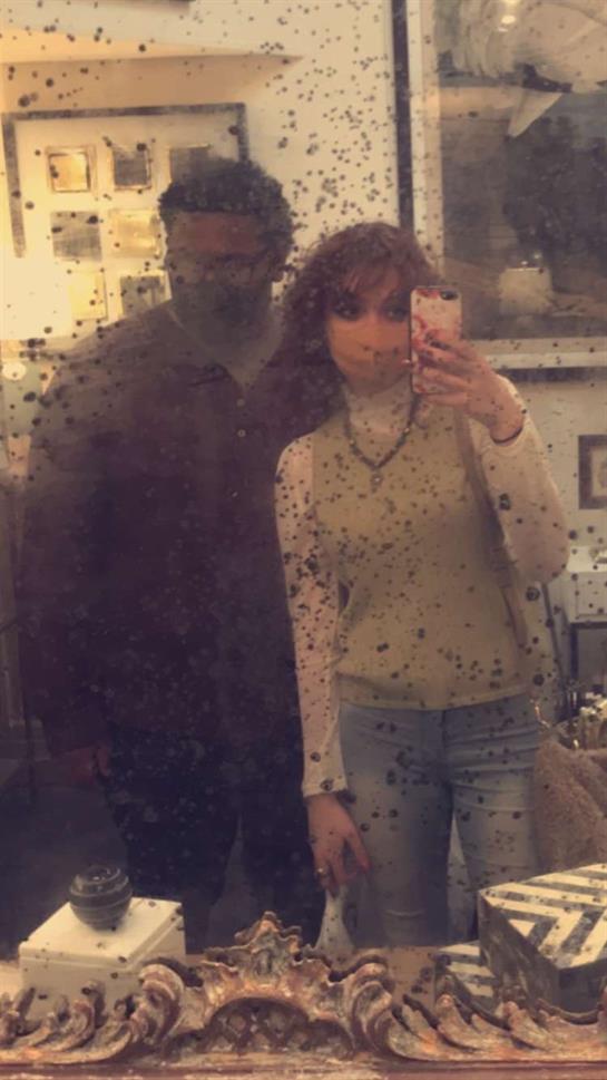 Couple shares a joyful selfie in a warm, inviting, personalized space.