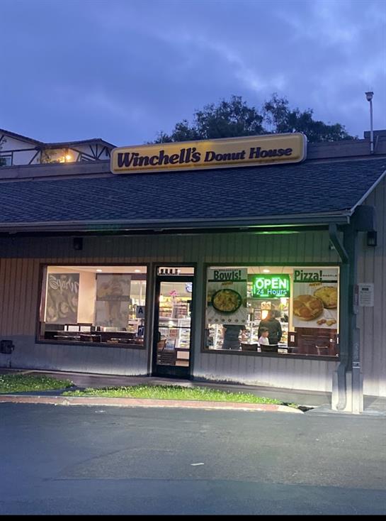 Winchells donut house welcomes customers at dusk with illuminated signage and a cozy vibe.
