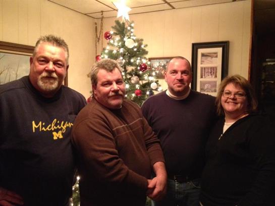 A group of people standing in front of a christmas tree