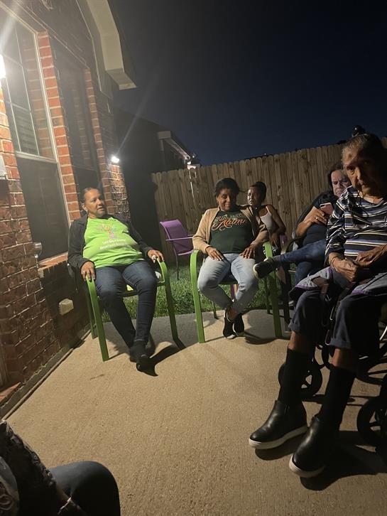 A group of people sitting on chairs outside