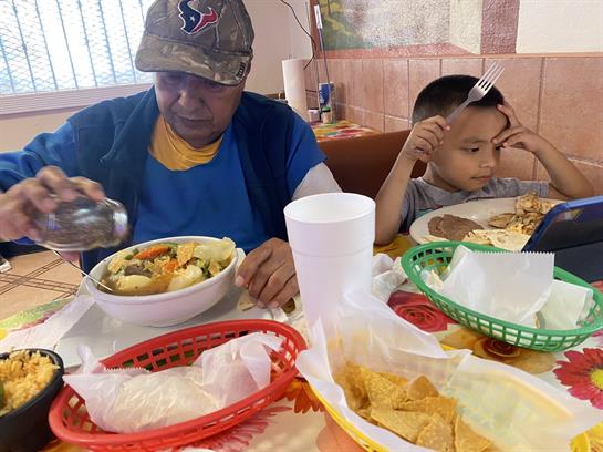A man and a boy savor a meal together, featuring colorful dishes and relaxed dining.