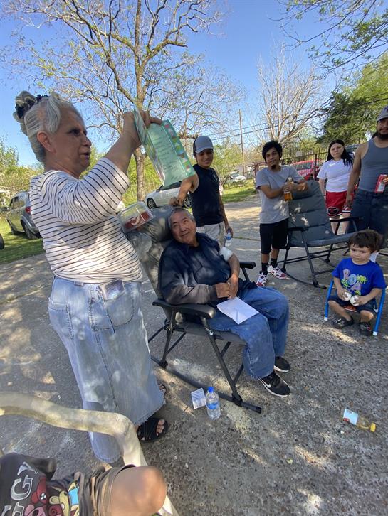 A lively park gathering sees participants enjoying activities and interacting on a sunny day.