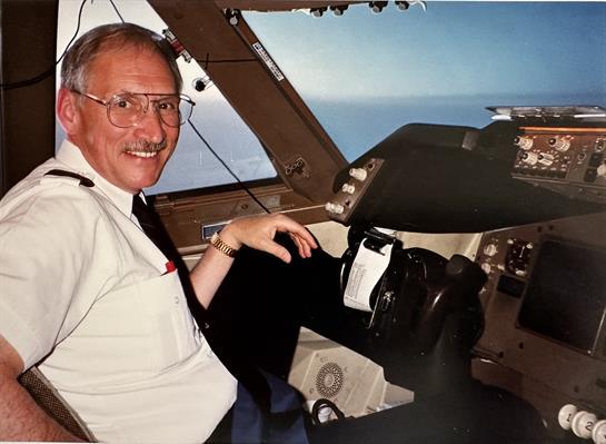 A pilot enjoys a moment in the cockpit, steering the aircraft while surrounded by instruments.