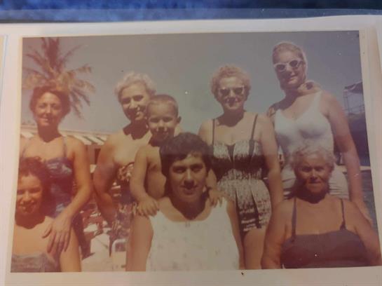A joyful family poses together at a poolside, enjoying a sunny day in summer.