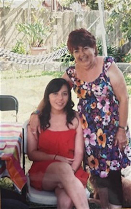 Women share joyful moments together at a family event, surrounded by a bright, natural setting.