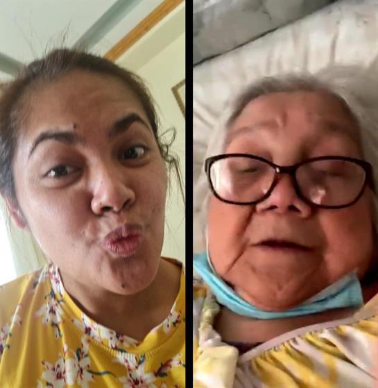 A caregiver interacts with an elderly woman, both sharing smiles and laughter in a hospital setting.