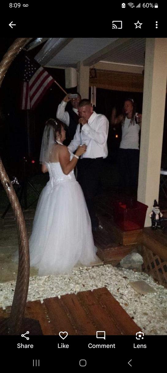 Two people celebrate their wedding by dancing together at a festive outdoor reception.