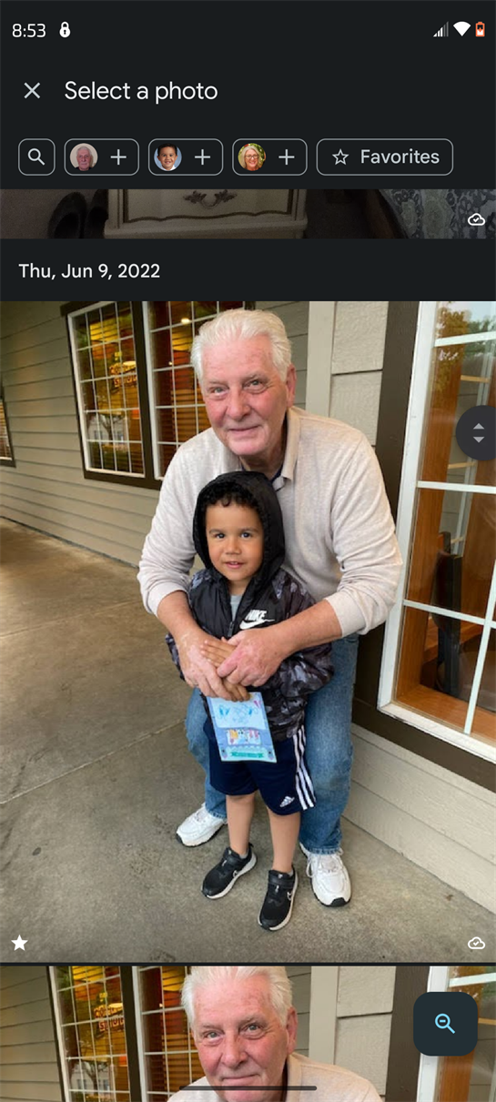 A joyful older man and a young child smile together outside a welcoming place.
