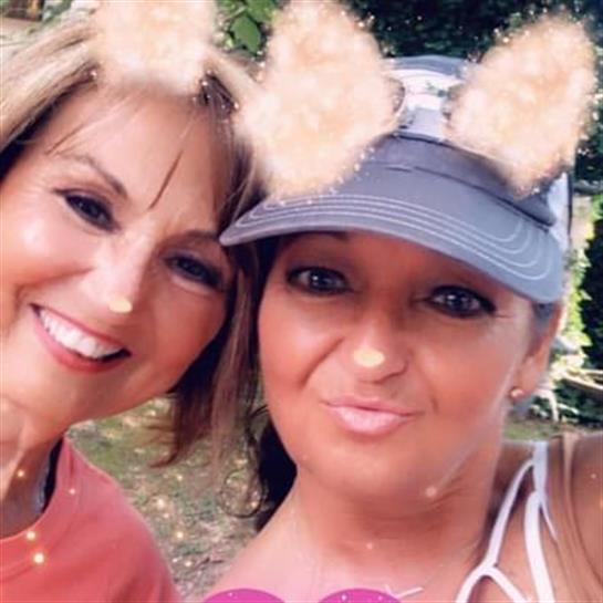 Two friends smile outdoors, enjoying a sunny day with playful filters on their faces.