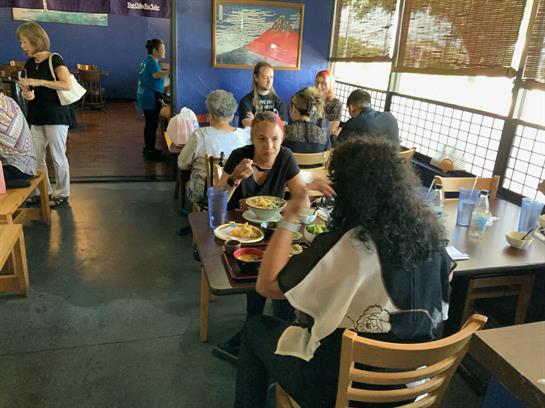 Diners savor their meals while chatting in a bustling restaurant setting during midday.