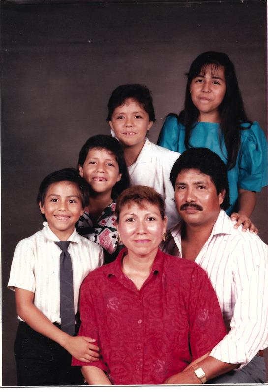 Family gathers for a joyful studio portrait, showcasing their smiles and togetherness.