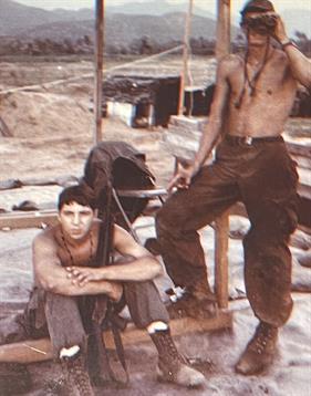 Two soldiers in training demonstrate camaraderie and readiness in their military gear.