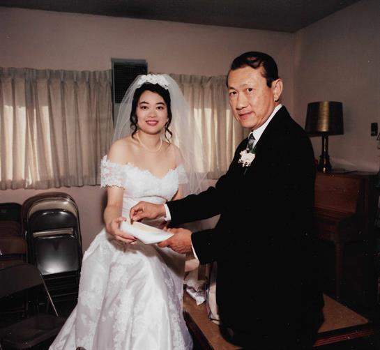 A newlywed couple participates in a traditional wedding ceremony exchanging items in celebration.