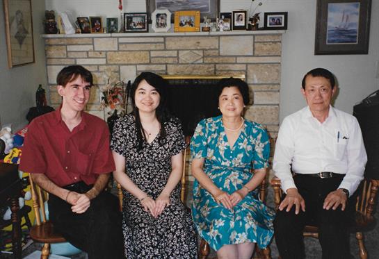 Four people share a joyful moment together in a comfortable living room with warm decor.