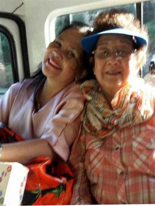 Two women enjoy each other's company on a bus ride, sharing smiles and warmth.