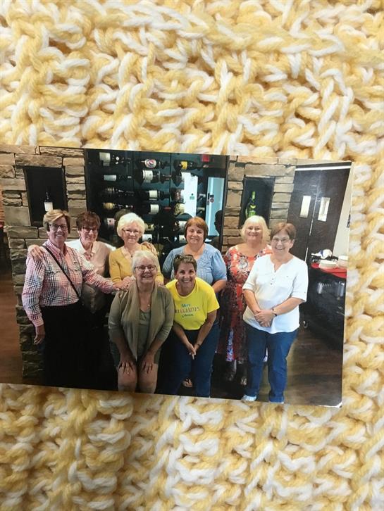 Friends enjoy their time together at a cozy venue, smiling and posing for a group picture.