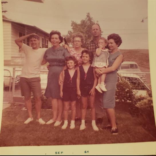 Group of relatives enjoying a cheerful moment together outside a home in September 1964.