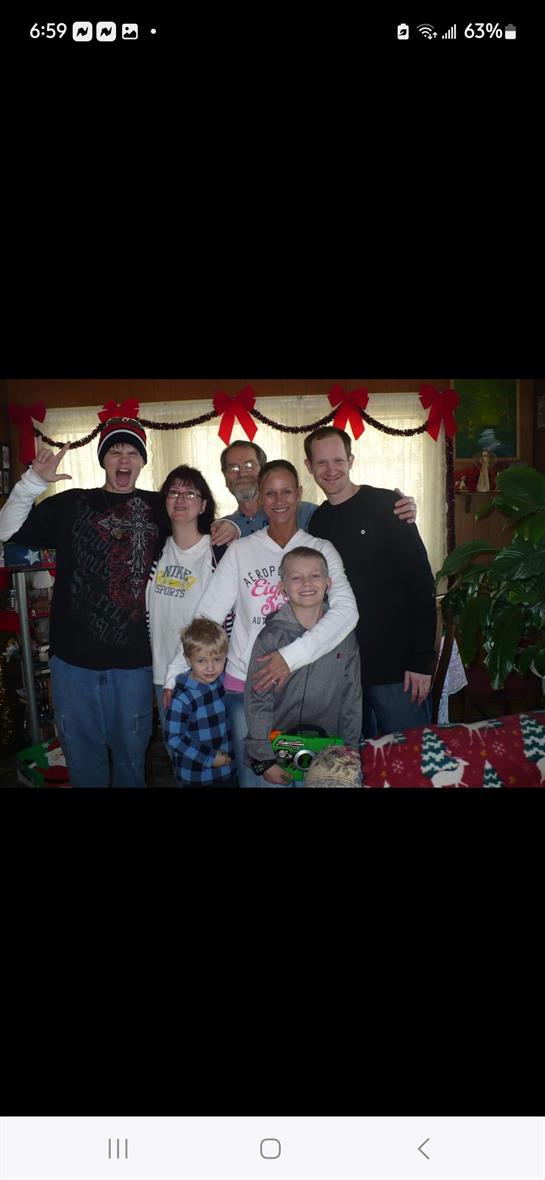 A cheerful family poses in cozy attire in a room decorated for winter festivities.