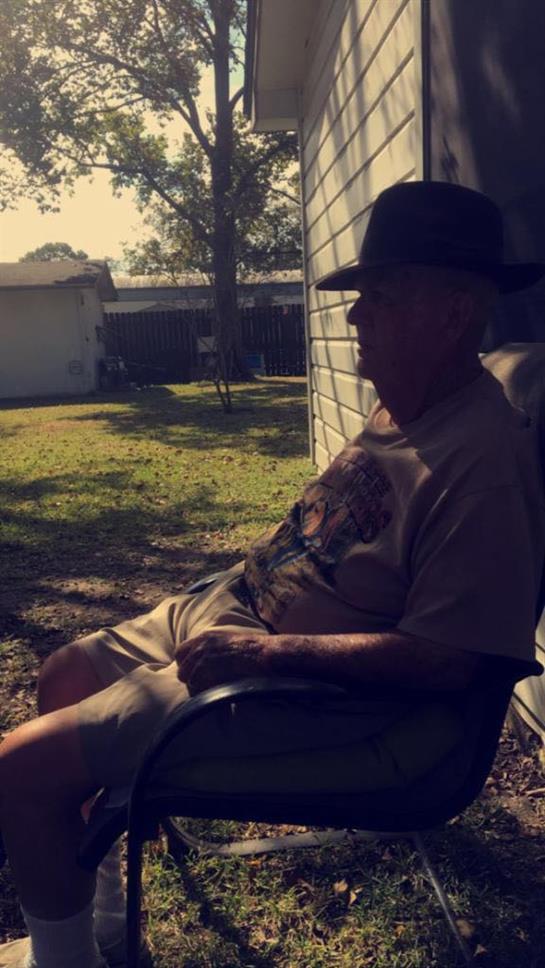 An older man enjoys a peaceful moment sitting in a chair, basking in the sun.