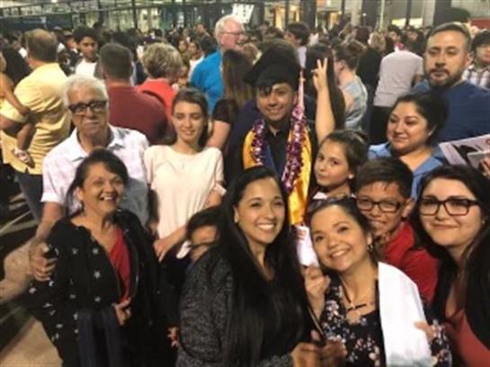 A joyful crowd interacts in a lively atmosphere at an evening celebration.