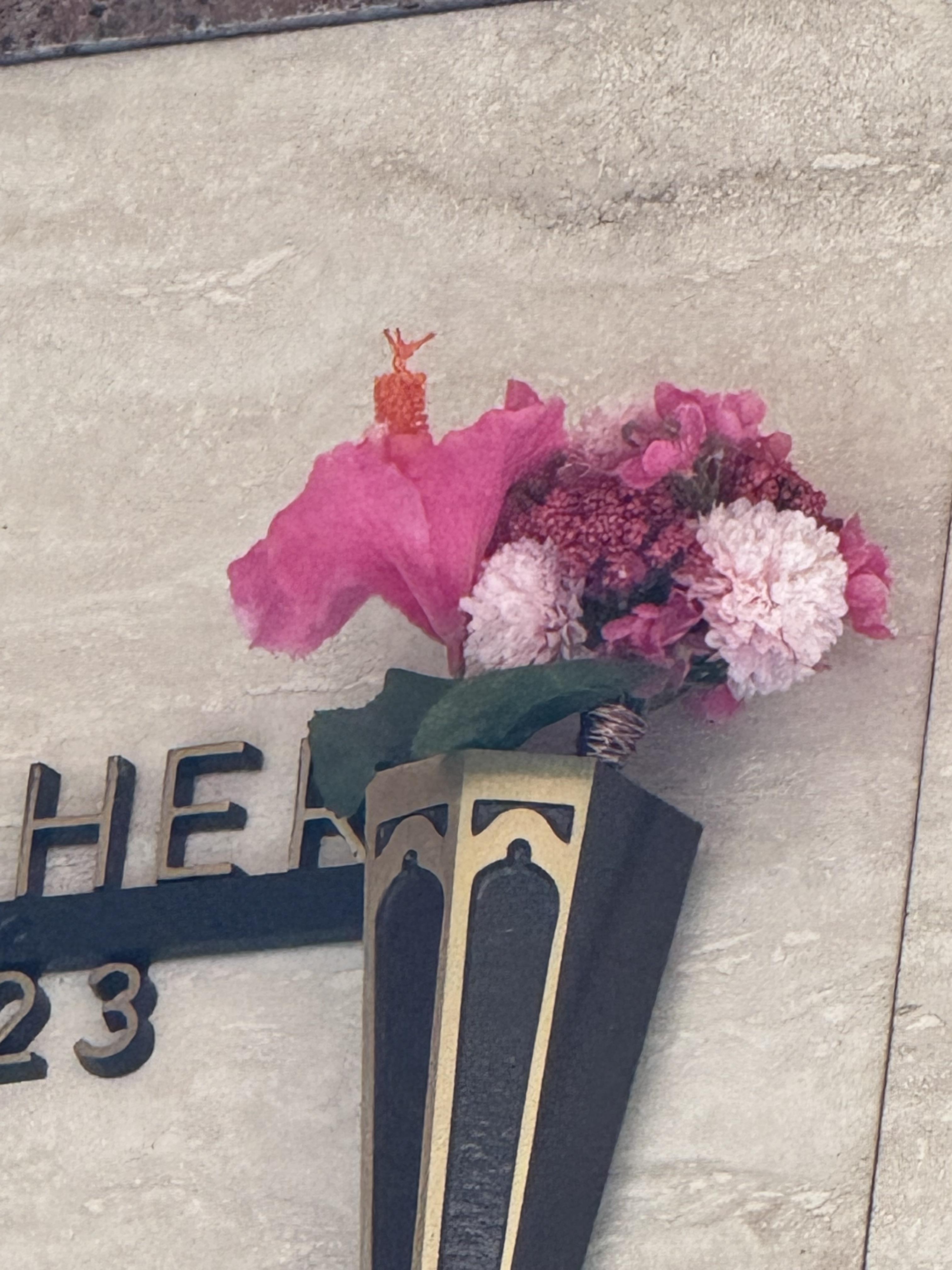 Colorful flowers in a vase honor someone's memory at a memorial site.