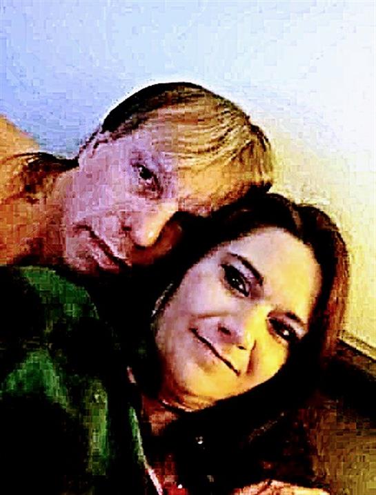 Two friends relax on a couch, enjoying each other's company during a cozy night.