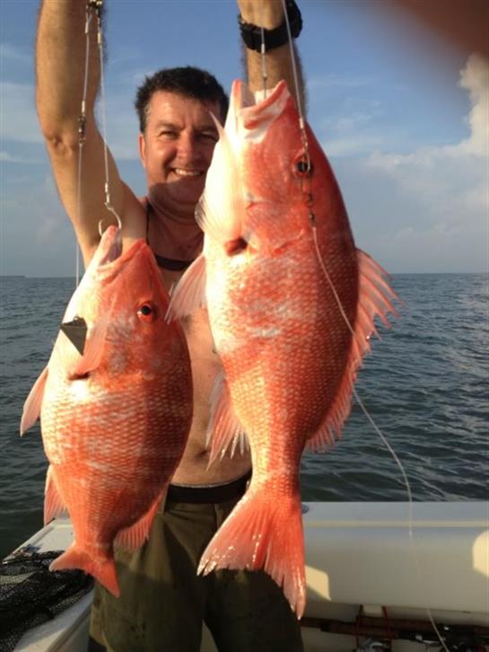 A man holding two fish