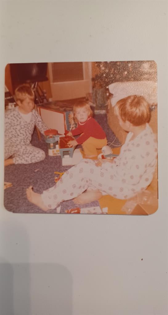 Three children enjoy playful activities on the floor of a warm living room, creating happy memories.