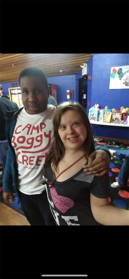 Two children pose happily at a bowling alley, enjoying a day filled with laughter and friends.