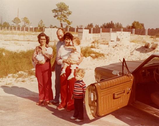 A group of people standing next to a car