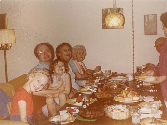 A group of people sitting at a table with food