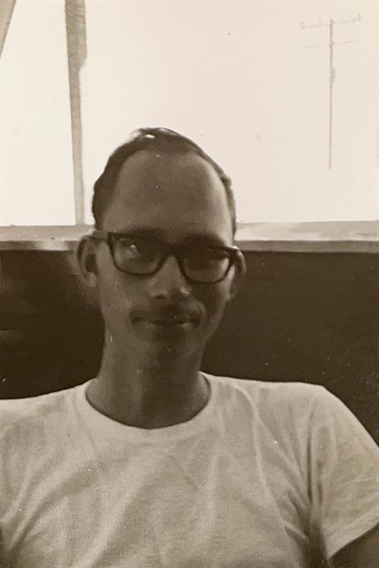 A man wearing glasses and a white shirt