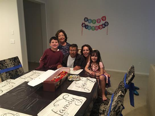 Family gathers around the dining table to celebrate a birthday, showcasing love and joy.