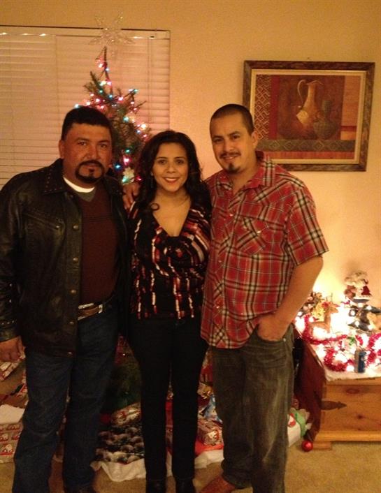 Three friends celebrate the holiday spirit by a decorated tree in a cozy living room.
