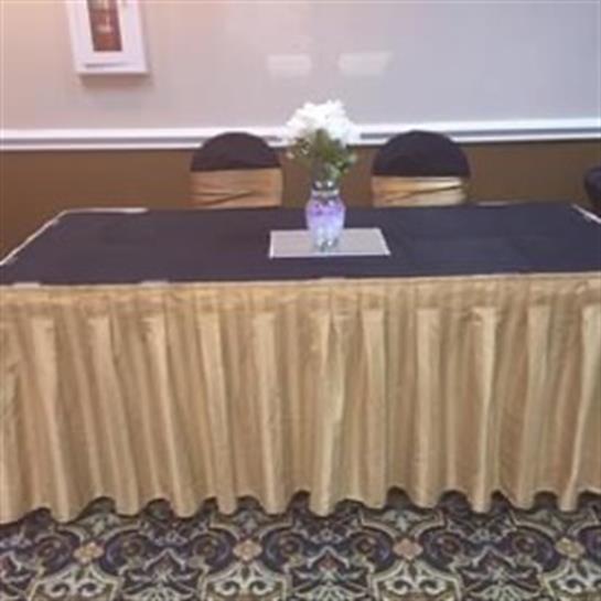 A tidy table with a floral centerpiece is set for an upcoming formal gathering.