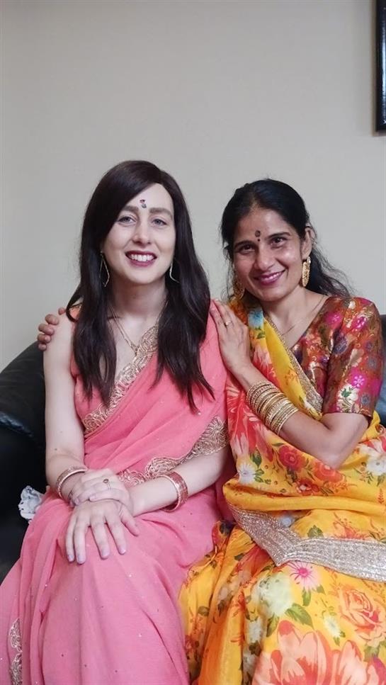 Friends celebrating culture while wearing vibrant traditional clothing in a relaxed indoor space.