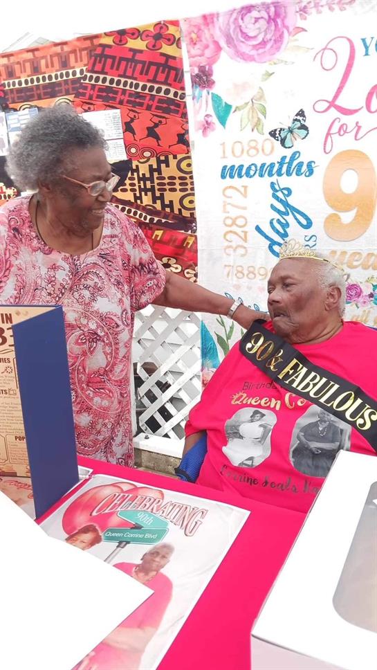 Elderly couple shares a heartfelt moment during a birthday celebration, surrounded by decorations.