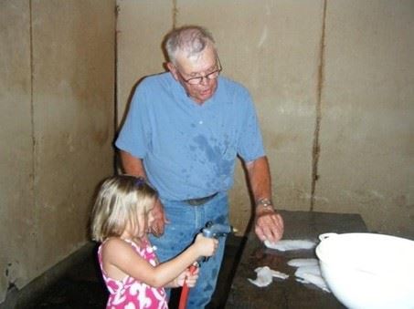A man and a little girl washing dishes