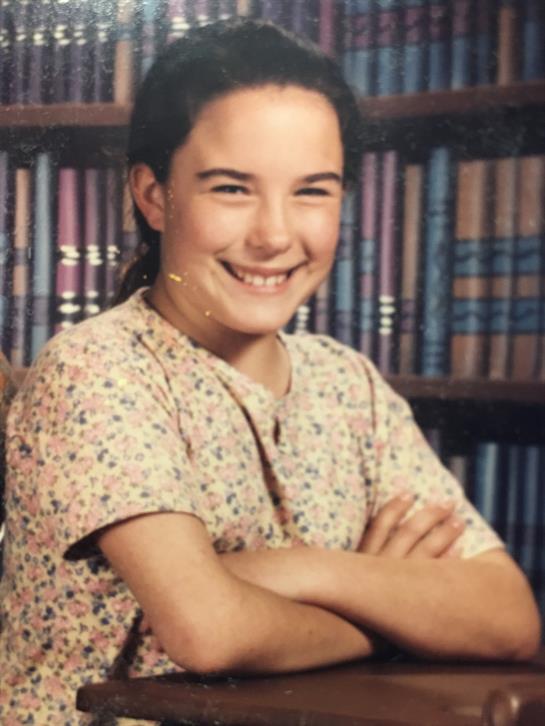 A girl smiling with her arms crossed