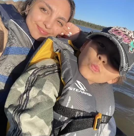 Two friends are happy and relaxed on a boat, enjoying a sunny day by the water.