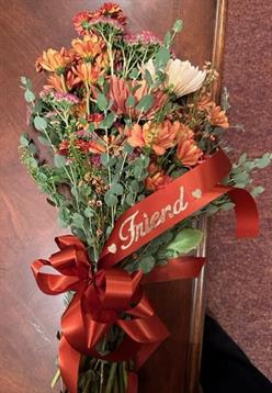 A bouquet of flowers with a red ribbon