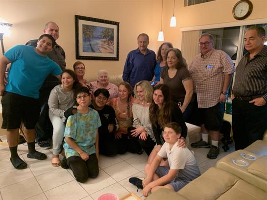A cheerful group of family and friends gathers in a cozy living room, enjoying time together.