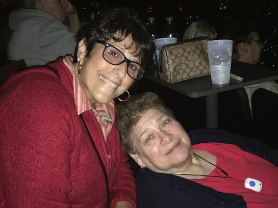 Two women sit close together, sharing smiles and laughter in a vibrant atmosphere filled with joy.