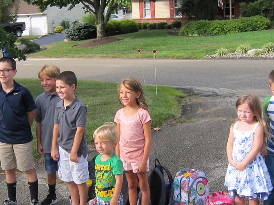 A group of children standing in front of a house