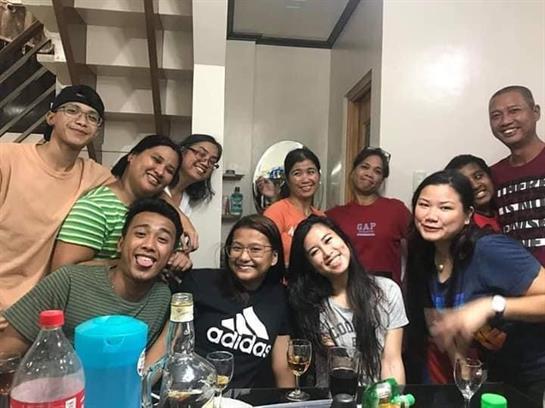 Group of friends enjoying drinks and laughter together in a warm, inviting atmosphere.