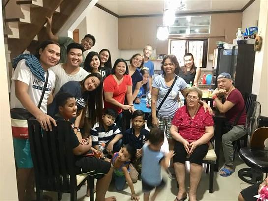 Group of family and friends enjoying quality time together in a warm living room setting.