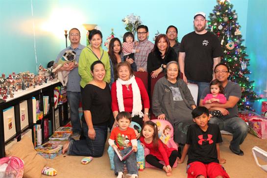 A joyful family gathers in the living room to celebrate the holidays together.