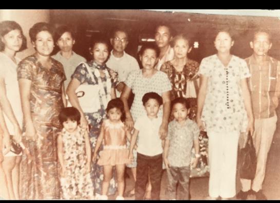 A group of family members smiling and posing together in a lively outdoor setting at night.